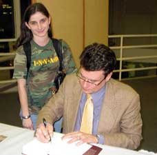 SHS student Amanda Novotny watches Jonathan Odell sign A View from Delphi for her. photo by Nancy Jacobs