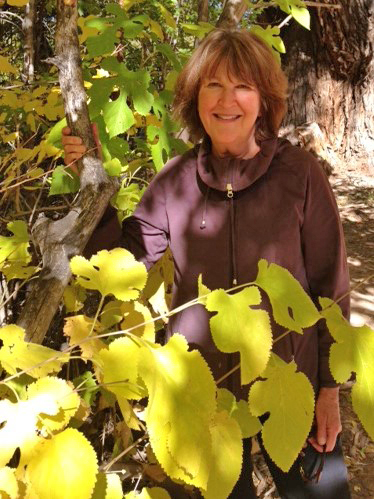 Author Minrose Gwin standing behind a mulberry tree